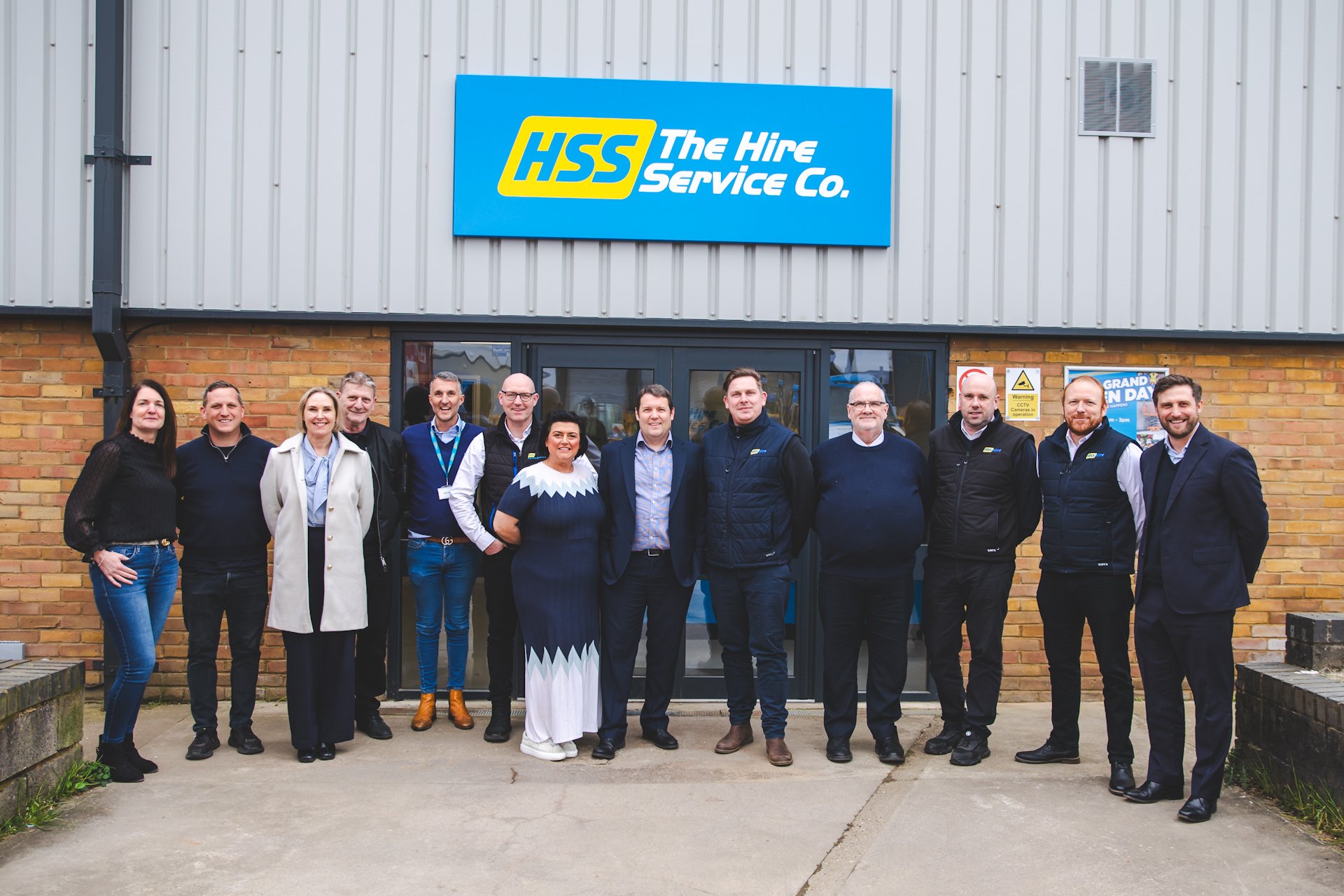 The Hire Service Company leadership and team members stand outside an HSS branch, reflecting the company’s return to its roots in a changing industry.